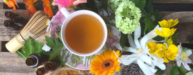 Sfeervolle homeopathie banner met bloemen en kop thee in natuurlijke setting