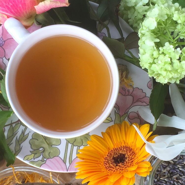 Sfeervolle homeopathie banner met bloemen en kop thee in natuurlijke setting