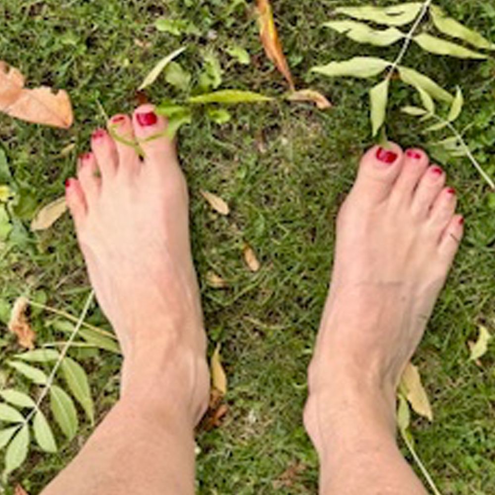 Blote voeten in het gras als natuurlijke manier van aarden tijdens gebruik van de zapper.
